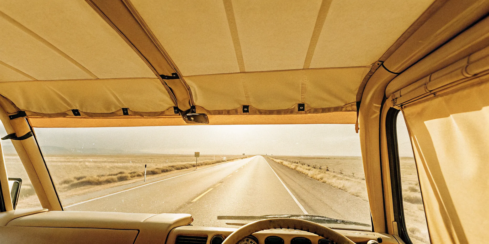 Owner-operator trucker driving an expedited freight truck on an open North American highway at dawn