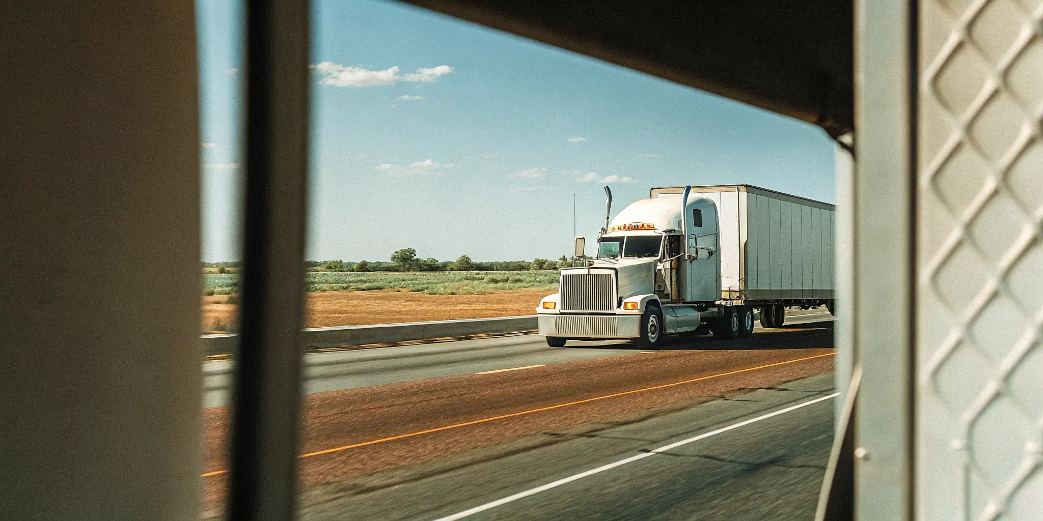 Load One semi truck moving down an open highway under a blue sky